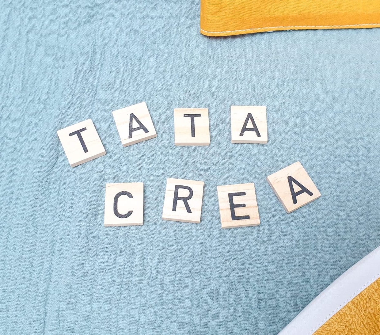 Lettres de scrabble qui écrivent "Tata créa"
