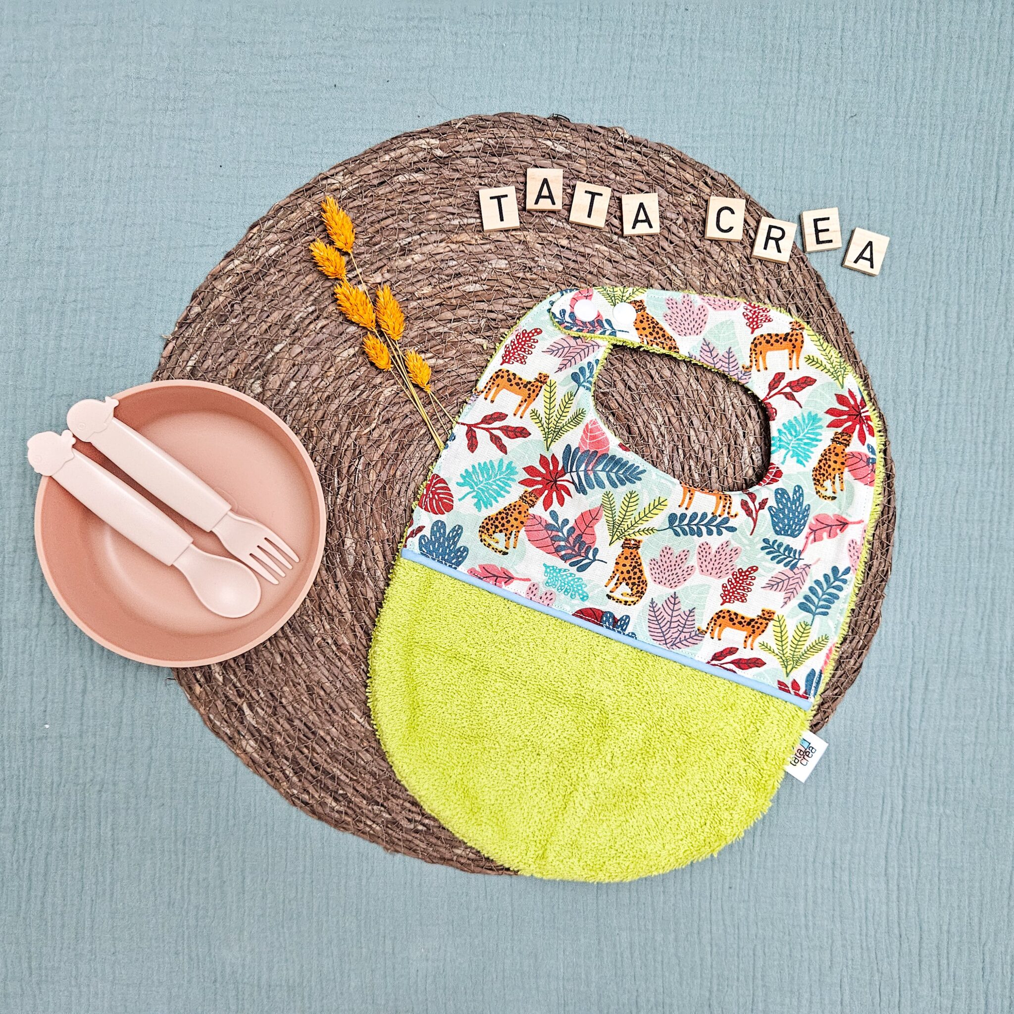 Bavoirs bébé (4 mois et plus). Coton à motifs "léopard fleuri", liseré intermédiaire bleu ciel, éponge vert anis – modèle Tata Créa