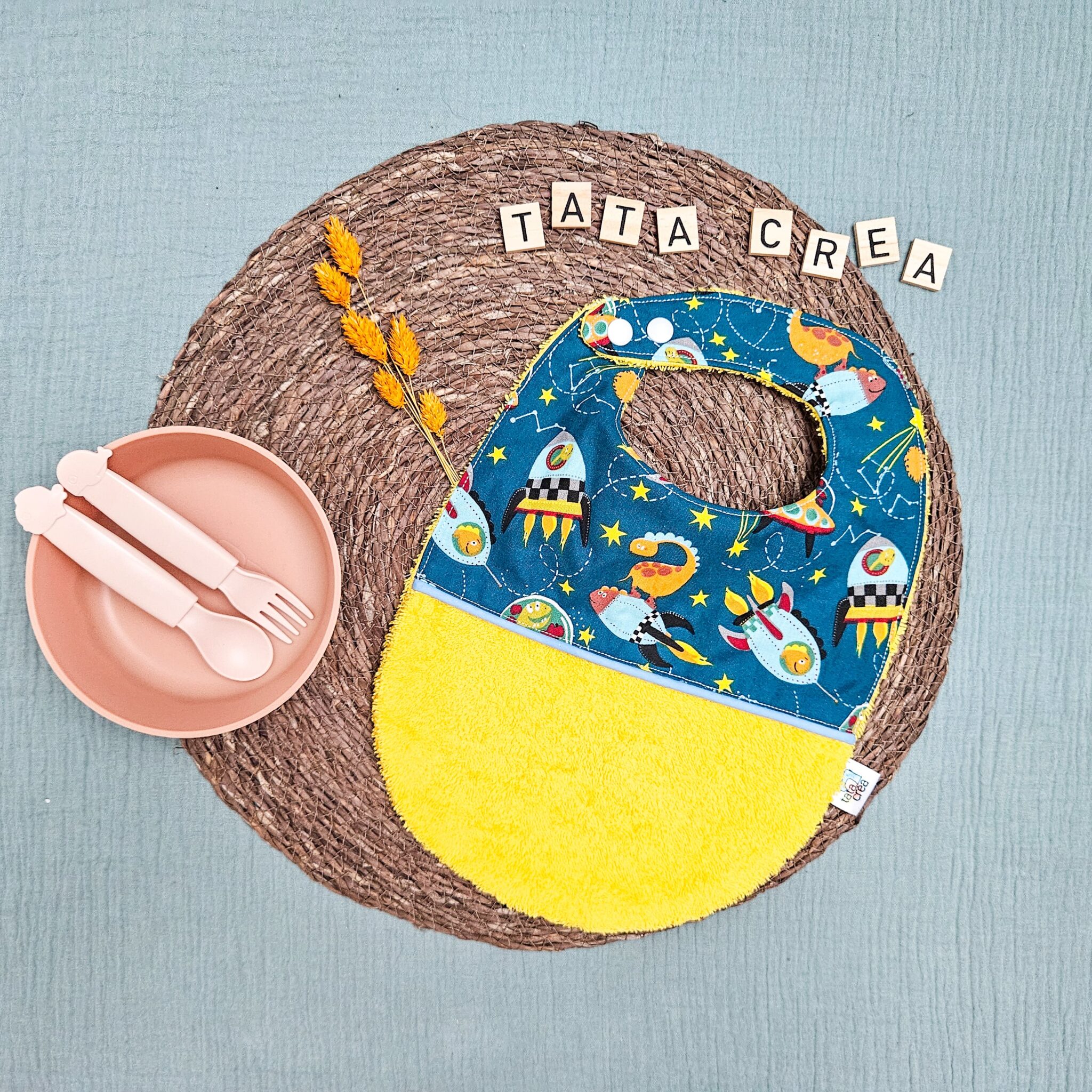 Bavoirs bébé (4 mois et plus). Coton à motifs "dinosaures de l'espace", liseré intermédiaire bleu ciel, éponge jaune – modèle Tata Créa