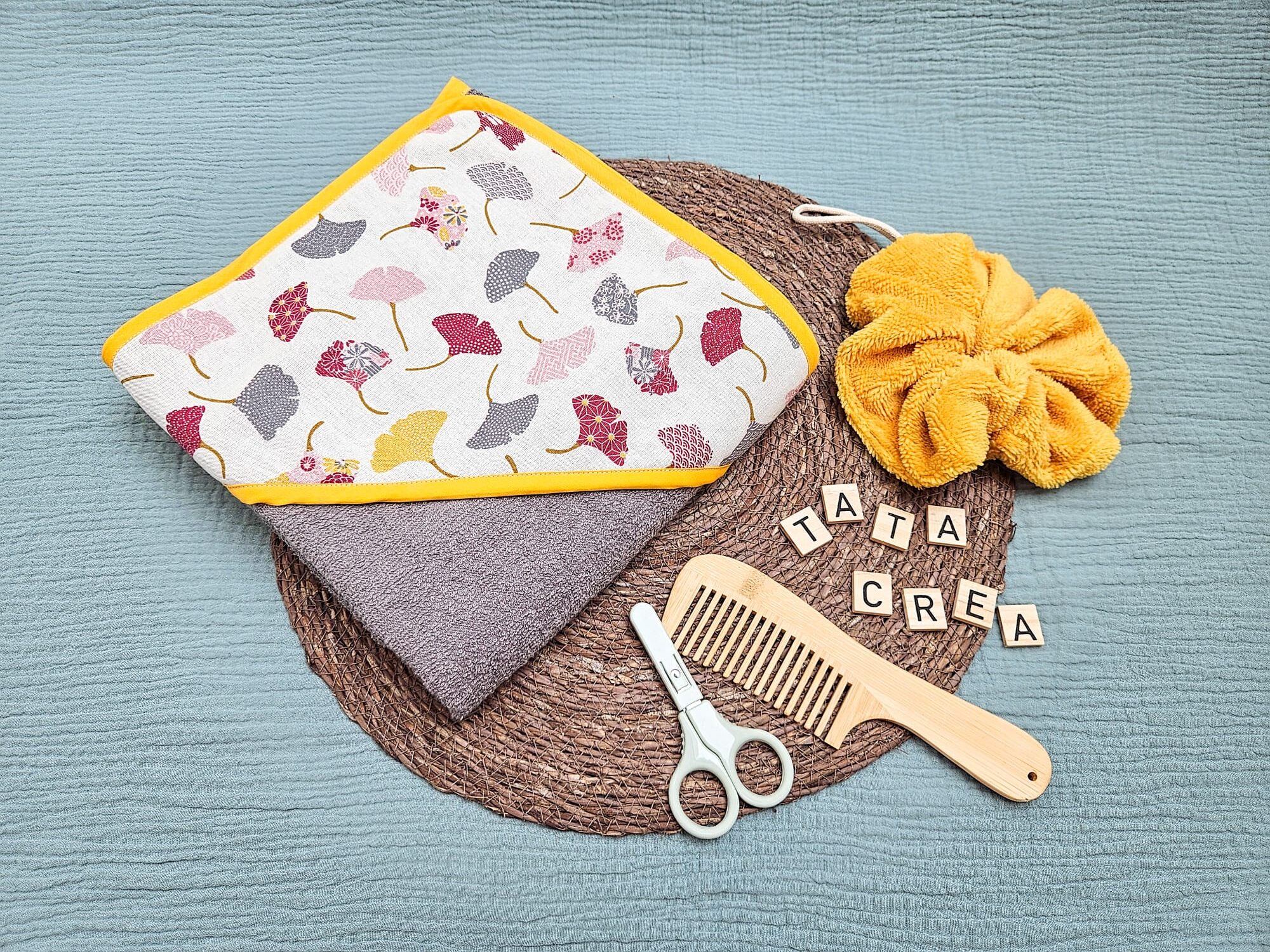 Cape de bain grand format - modèle tata créa. Coton à motifs "fleurs de ginkgo", biais jaune, éponge grise, en attente de personnalisation.