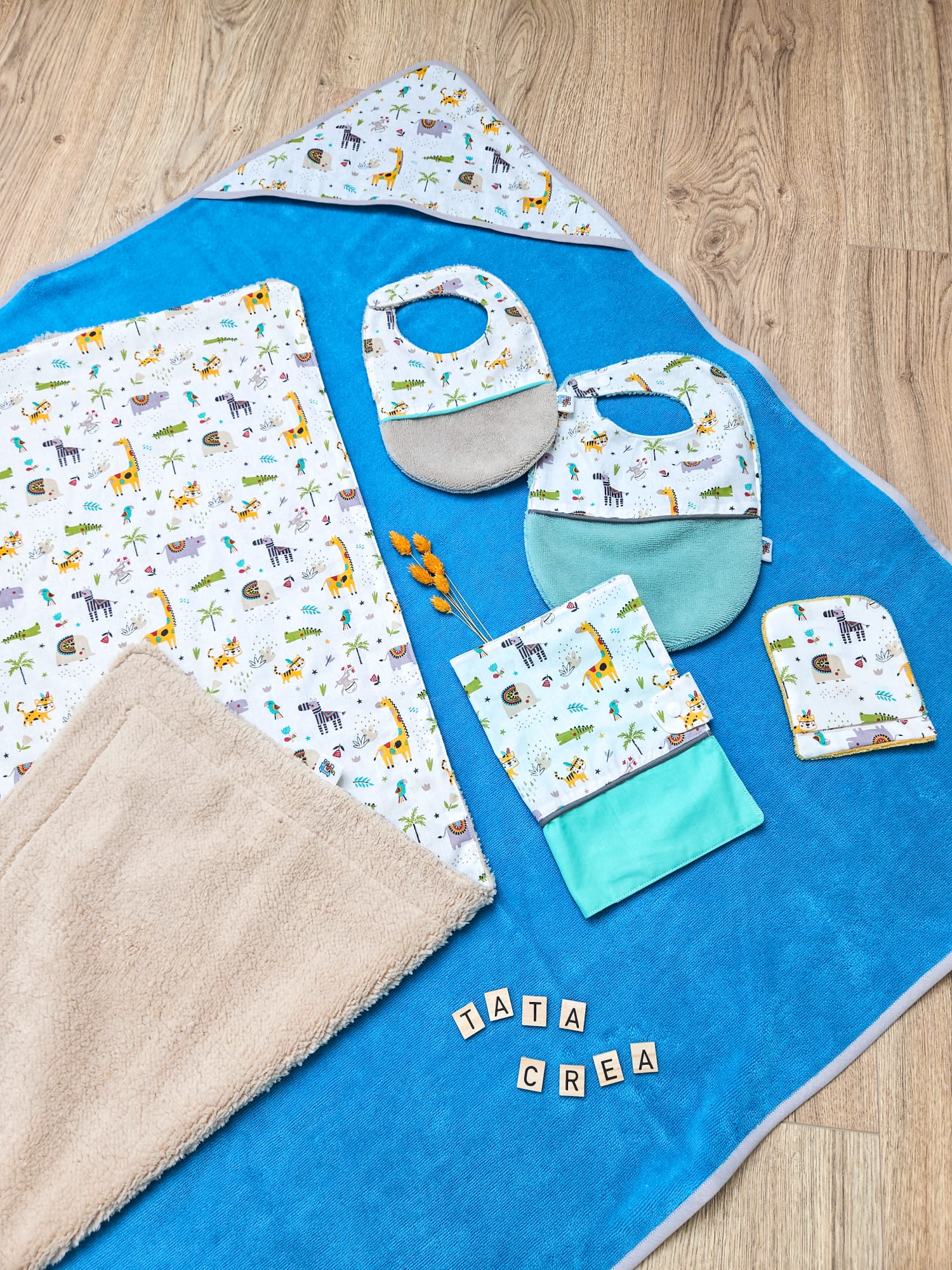 Lot anniversaire, composé d'une cape de bain, d'une couverture bébé, d'un bavoir nourrisson, d'un bavoir bébé, d'un gant de toilette, d'un protège carnet de santé