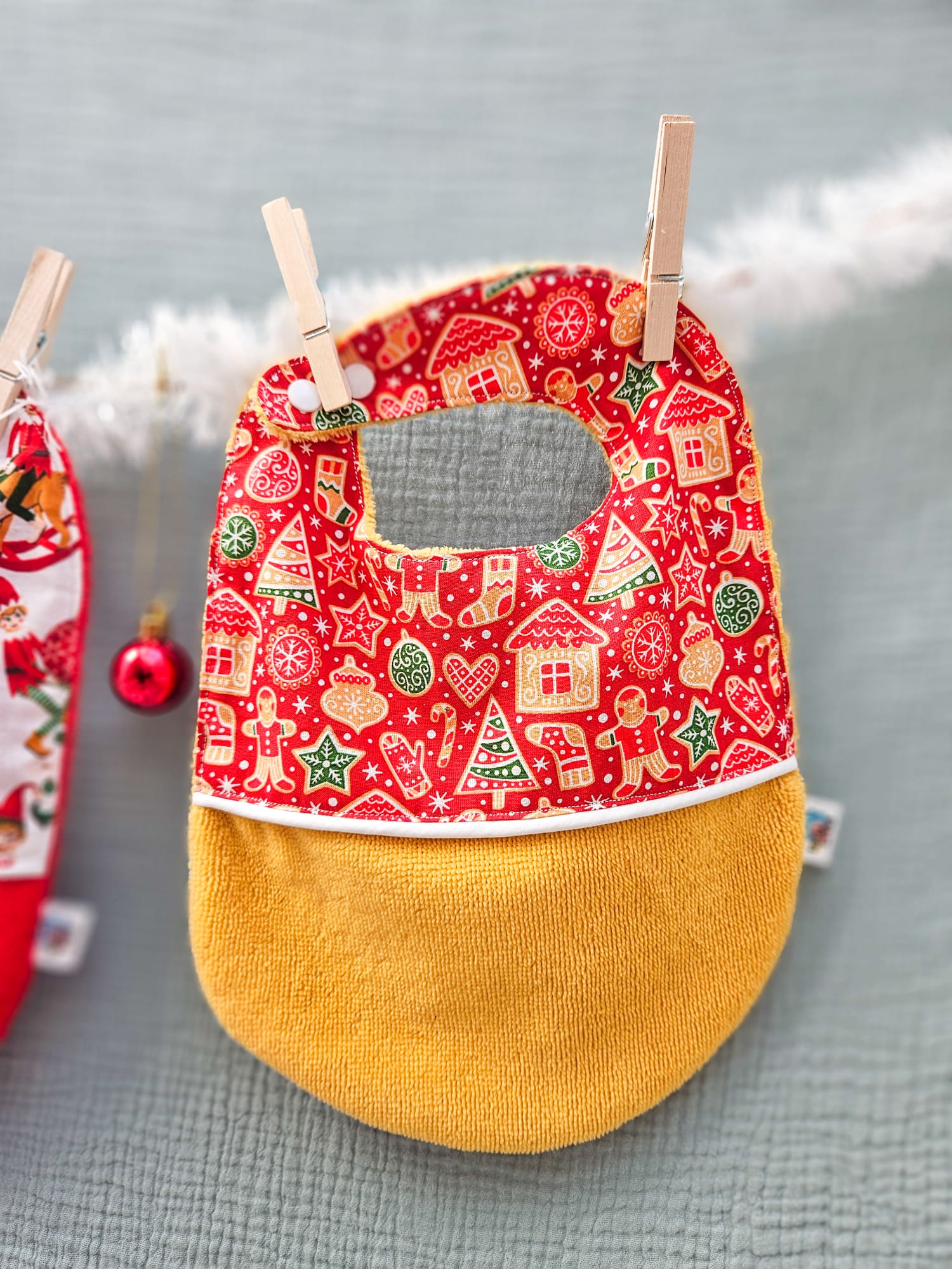 Bavoirs de Noël bébé (4 mois et plus). Coton à motifs "petit biscuit rouge", liseré intermédiaire blanc, éponge ocre – modèle Tata Créa