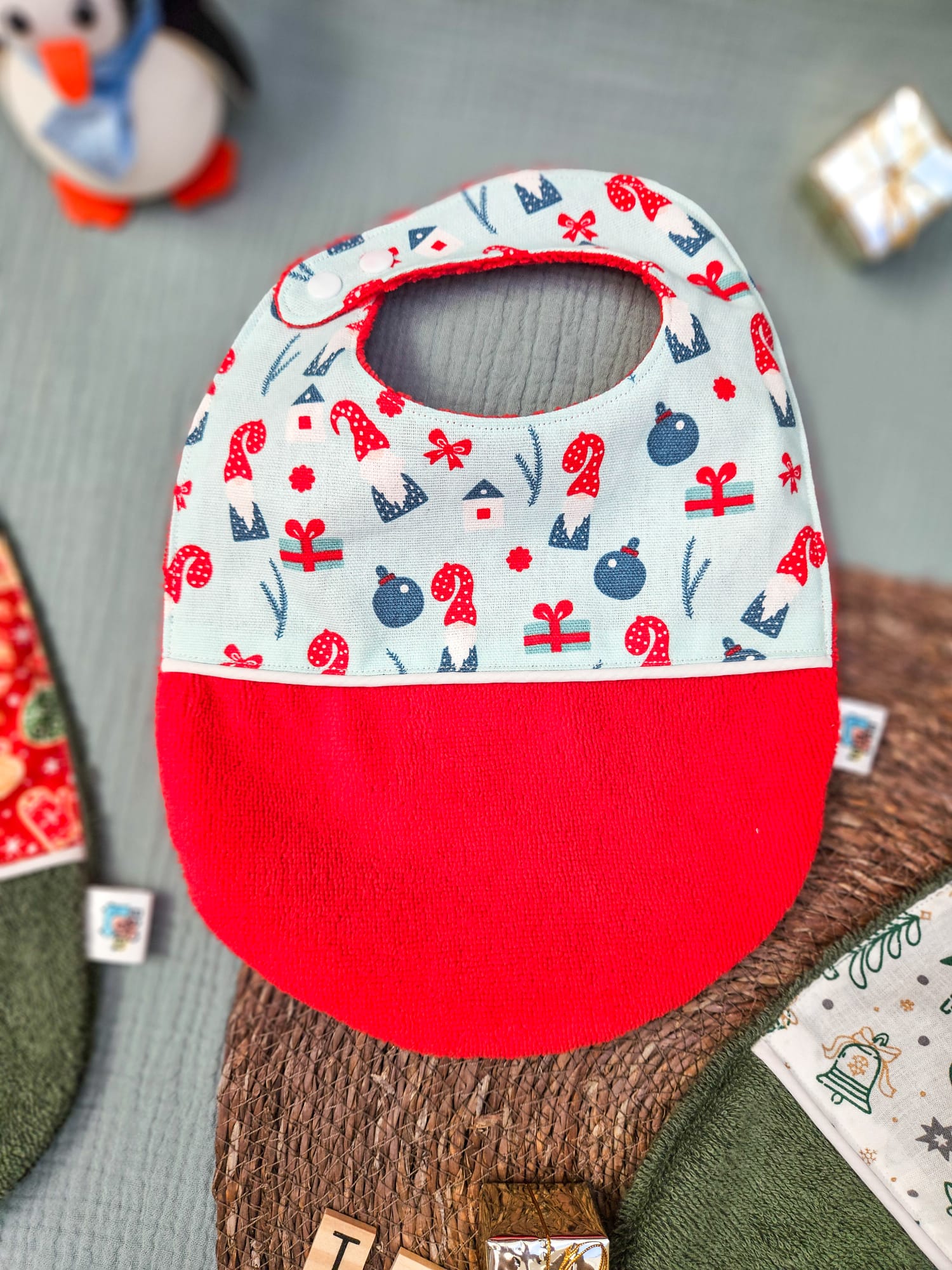 Bavoirs de Noël bébé (4 mois et plus). Coton à motifs "gnomes bleu ciel", liseré intermédiaire blanc, éponge rouge – modèle Tata Créa