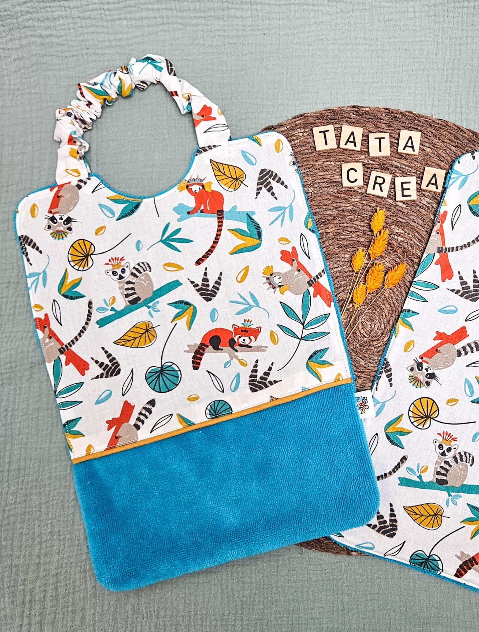 Serviette élastiquée pour la maternelle - Coton à motifs "lémuriens et ratons laveurs", liseré intermédiaire ocre, éponge bleu lagon – modèles Tata Créa