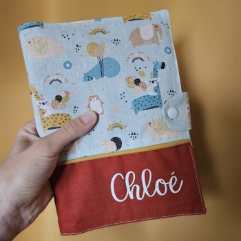 Carnet de santé personnalisé au prénom de Chloé. Tissu motifs "au dodo" et uni terracotta, passepoil ocre – modèle Tata Créa